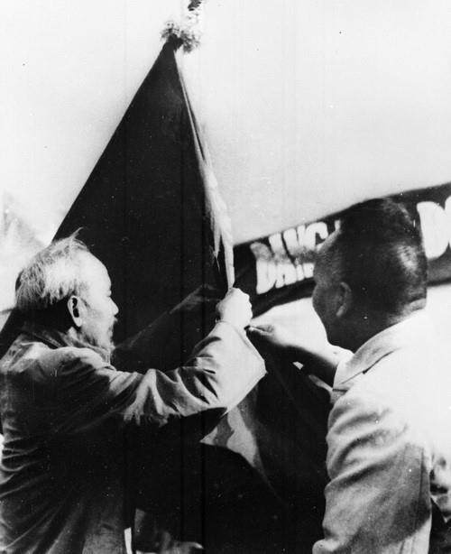 Chủ tịch Hồ Chí Minh gắn tặng Huân chương lên quân kỳ của Sư đoàn 355 tập kết từ chiến trường về (1965). (Ảnh: TTXVN)