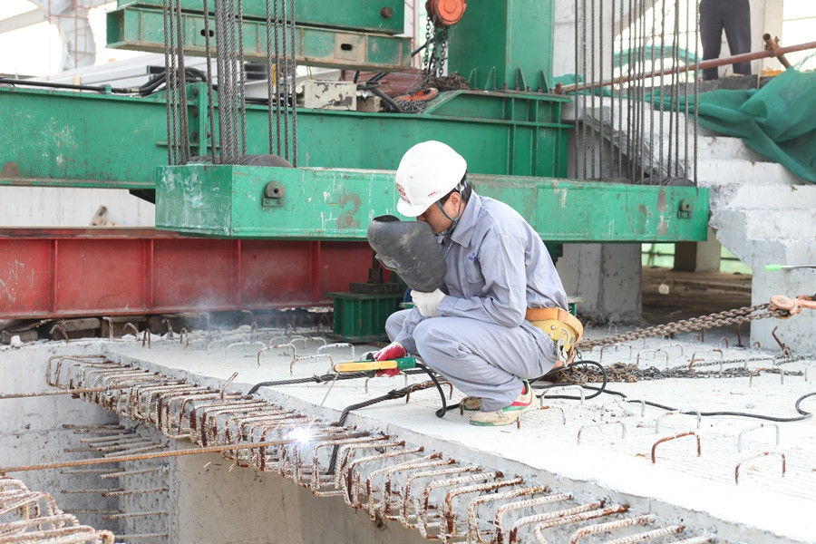 Công nhân tiếp tục thi công hàn các mối sắt sau khi hợp long phiến dầm. (Ảnh: Doãn Đức/Vietnam+)