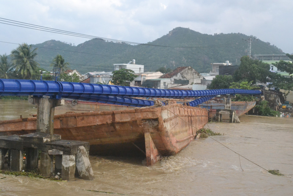 Tại Khánh Hòa, mưa lũ khiến 2 chiếc sà lan cỡ lớn trôi từ thượng nguồn sông Cái Nha Trang về và mắc kẹt tại khu vực cầu Hà Ra, đánh sập đường ống dẫn nước Nha Trang. (Ảnh: Phan Sáu/TTXVN)
