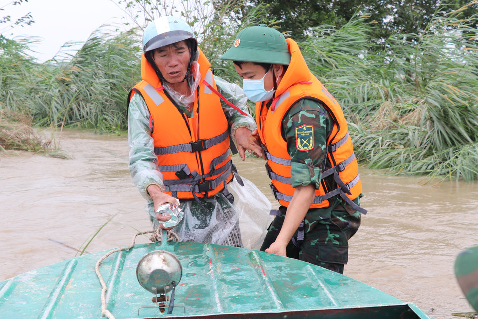 Các cán bộ, chiến sỹ Bộ Chỉ huy quân sự tỉnh Phú Yên tiếp cận khu vực nơi ông Mai Tấn Phùng, 56 tuổi, thôn Phước Lộc 2, xã Hòa Thành bị mắc kẹt do nước lũ. (Ảnh: Phạm Cường/TTXVN)