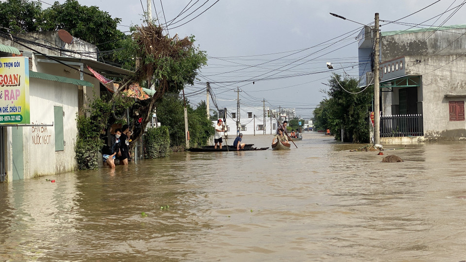Tuyến đường trục chính xã Phước Nghĩa chìm trong nước lũ, người dân di chuyển bằng ghe, thuyền. (Ảnh: Tường Quân/TTXVN)