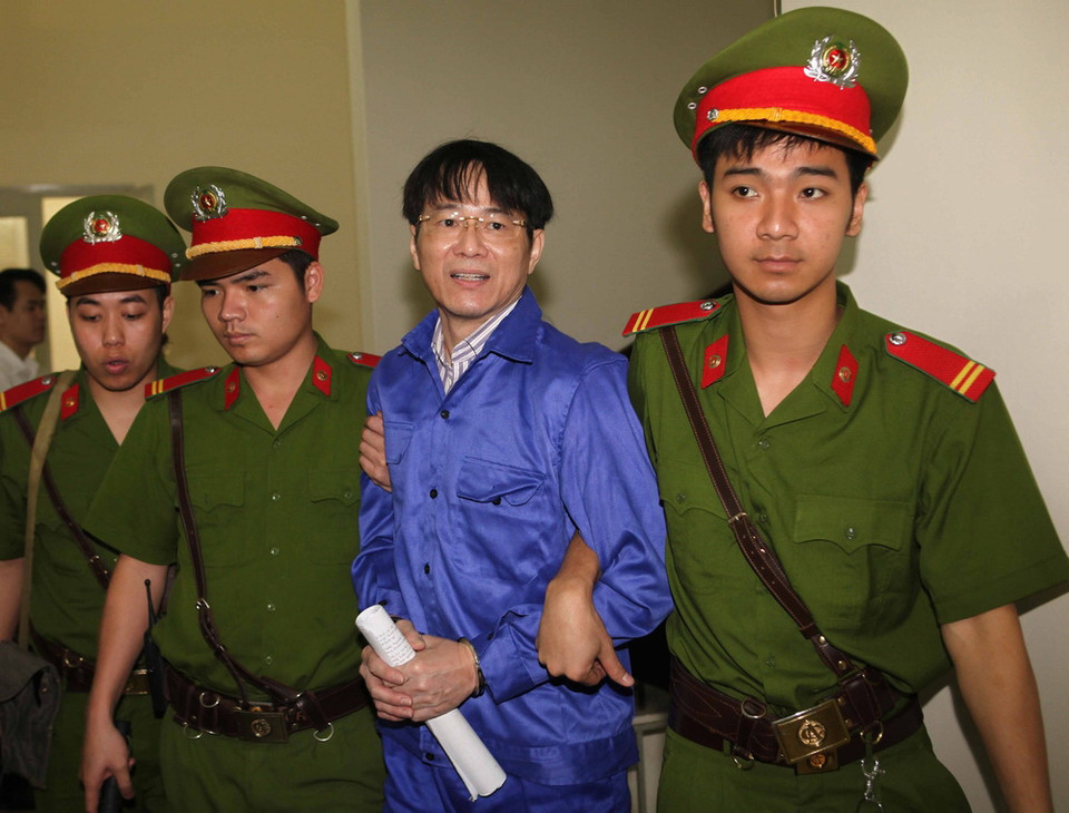 Dẫn giải bị cáo Lý Xuân Hải, nguyên Tổng Giám đốc Ngân hàng ACB vào phòng xét xử. (Ảnh: Doãn Tấn/TTXVN)