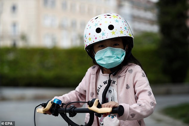 Một bé gái đeo khẩu trang phòng chống dịch khi ra ngoài.