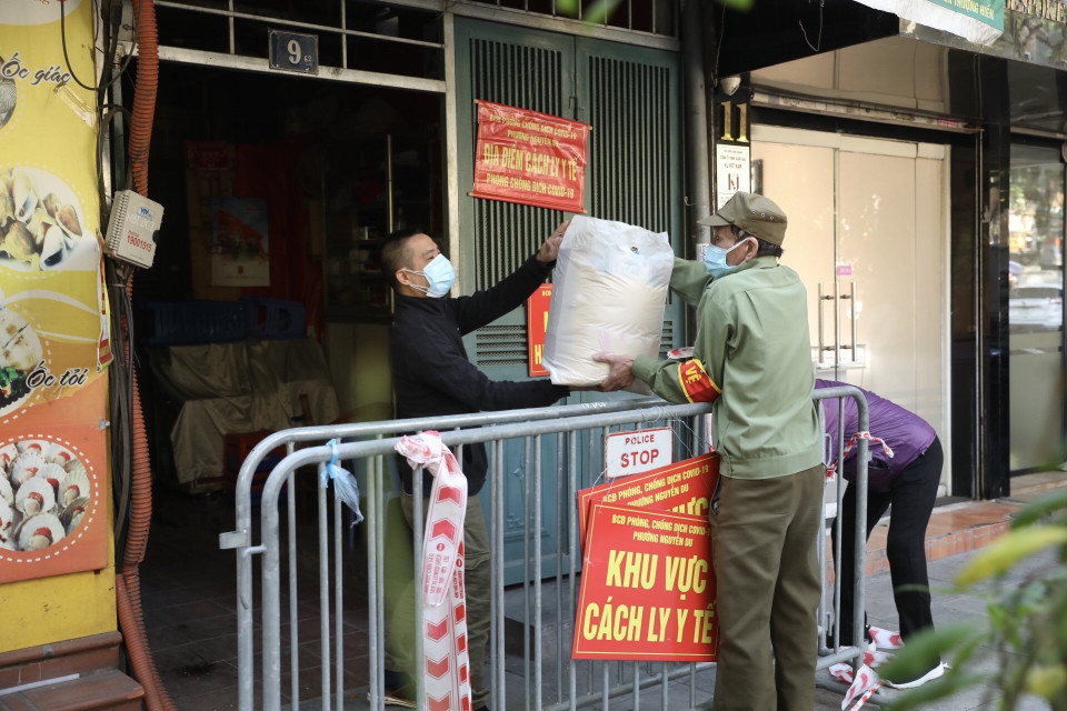 Lực lượng chức năng phường Nguyễn Du, quận Hai Bà Trưng hỗ trợ các hộ gia đình bị cách ly y tế, giúp người dân yên tâm thực hiện tốt các biện pháp phòng, chống dịch. (Ảnh: Minh Quyết/TTXVN)