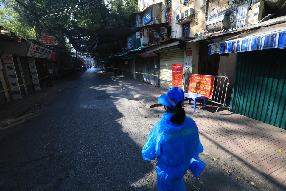 Nhân viên vệ sinh mặc đồ bảo hộ trước khi vào khu vực phong tỏa. (Ảnh: Tuấn Anh/TTXVN)