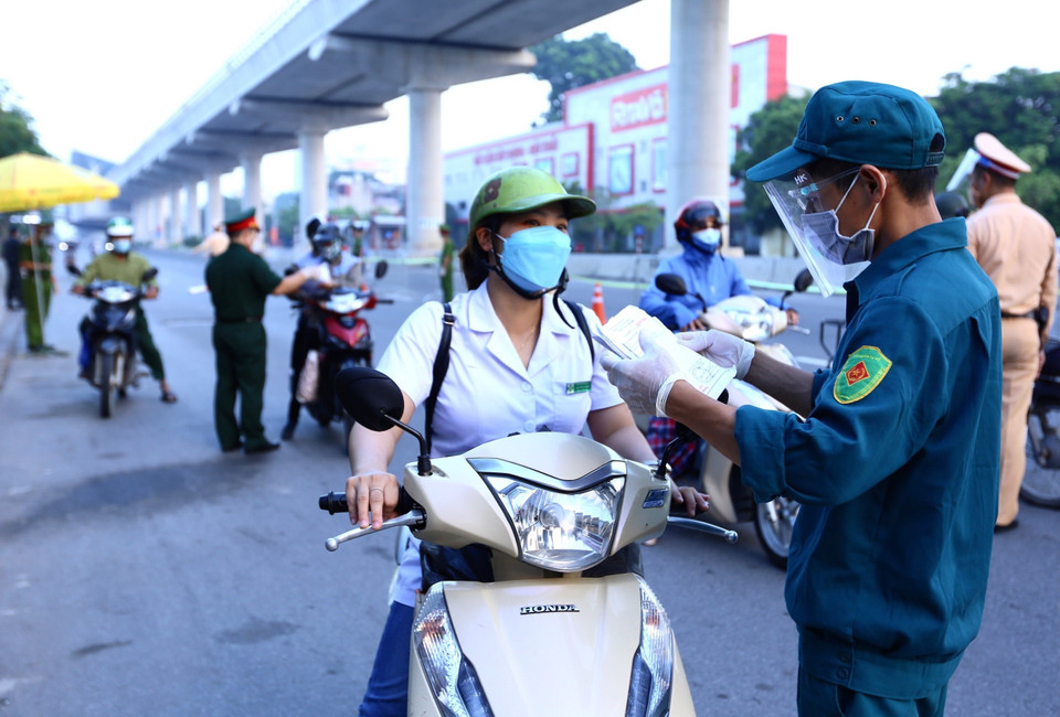 Để giải quyết tình trạng ùn tắc vào sáng đầu tuần (6/9/2021), ngày 7/9, lực lượng chức năng đã tăng thêm 5 người trực chốt, đồng thời tổ chức phân luồng từ xa, sử dụng loa tuyên truyền yêu cầu người dân cầm sẵn giấy tờ trên tay để giảm thời gian kiểm tra, kiểm soát. (Ảnh: Hoàng Hiếu/TTXVN)