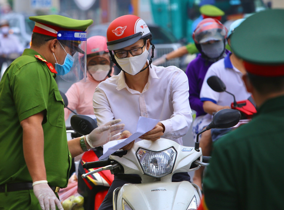 Mọi người dân đều phải có giấy tờ hợp lệ nếu muốn qua chốt Cầu Diễn. (Ảnh: Hoàng Hiếu/TTXVN)