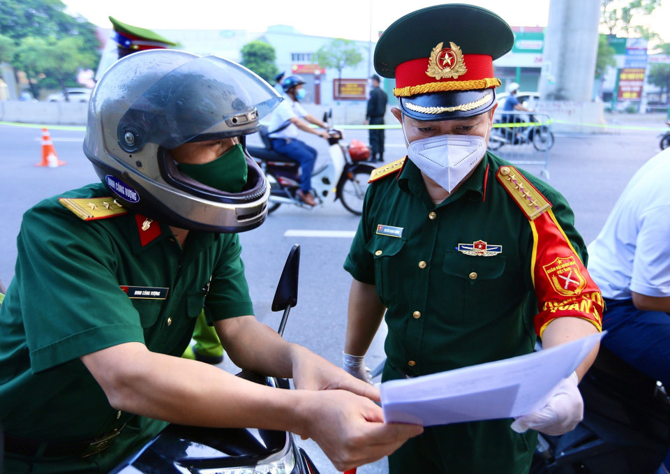 Lực lượng trực chốt Cầu Diễn kiểm tra giấy tờ tất cả người muốn đi qua. (Ảnh: Hoàng Hiếu/TTXVN)