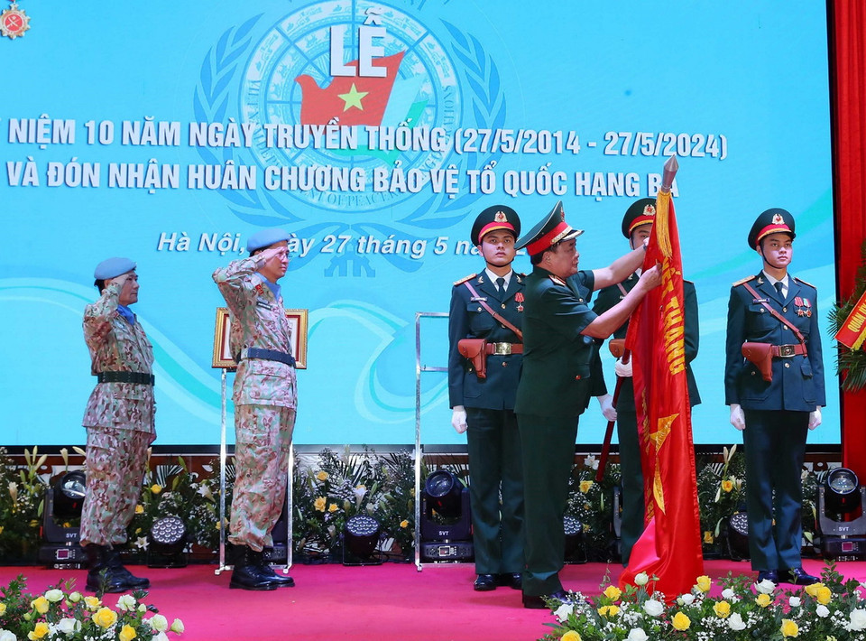 Thượng tướng Hoàng Xuân Chiến, Thứ trưởng Bộ Quốc phòng gắn Huân chương Bảo vệ Tổ quốc hạng Ba lên cờ của Đội Công binh số 1. (Ảnh: Trọng Đức/TTXVN)