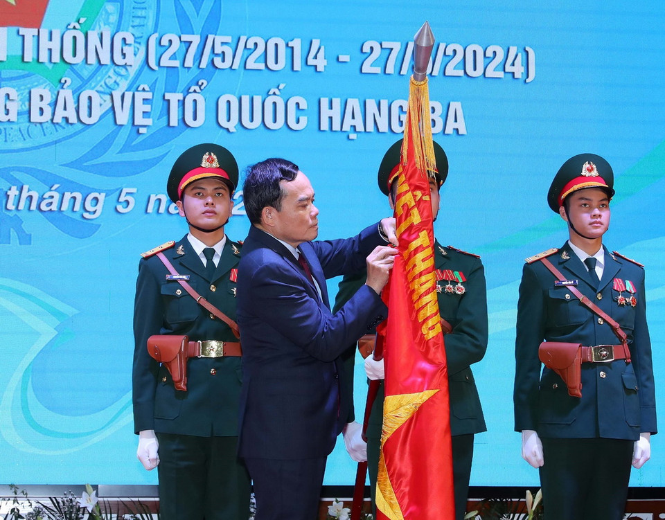 Phó Thủ trưởng Trần Lưu Quang gắn Huân chương Bảo vệ Tổ quốc hạng Ba lên cờ truyền thống của Cục Gìn giữ Hòa bình Việt Nam. (Ảnh: Trọng Đức/TTXVN)