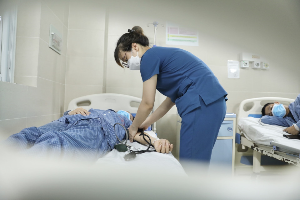 Điều dưỡng chăm sóc bệnh nhân đang điều trị cúm A tại bệnh viện Thanh Nhàn. (Ảnh: Minh Quyết/TTXVN)