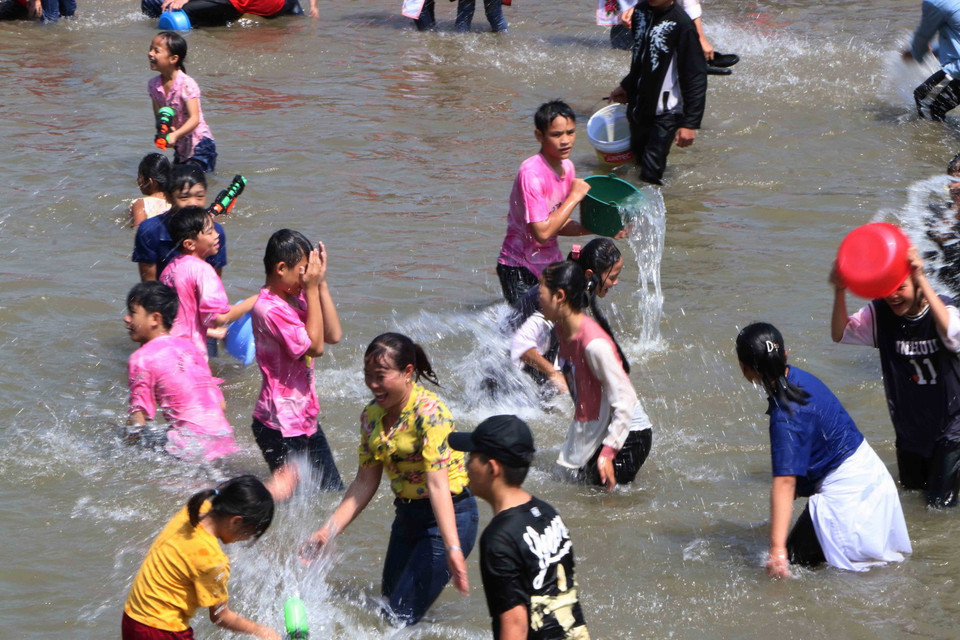 Người dân và du khách phấn khích chơi té nước tại lễ hội. (Ảnh: Nguyễn Oanh/TTXVN)