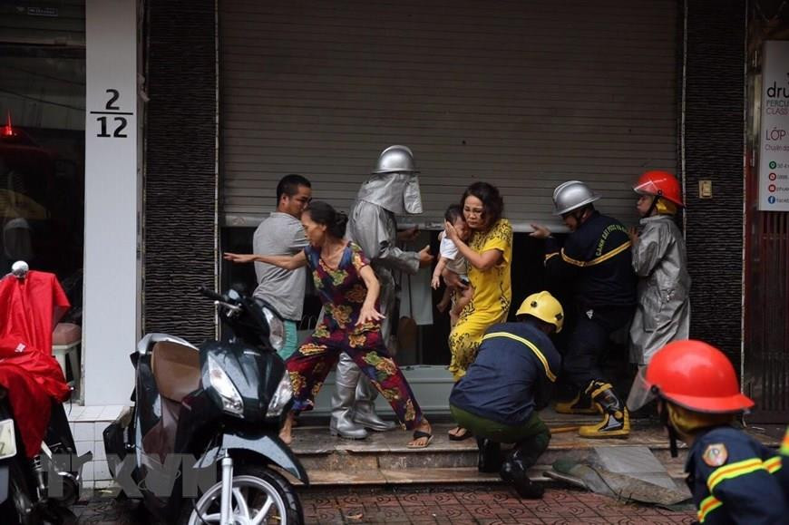 Lực lượng chữa cháy đưa người dân ra khỏi hiện trường. Ảnh: Dương Giang/TTXVN)