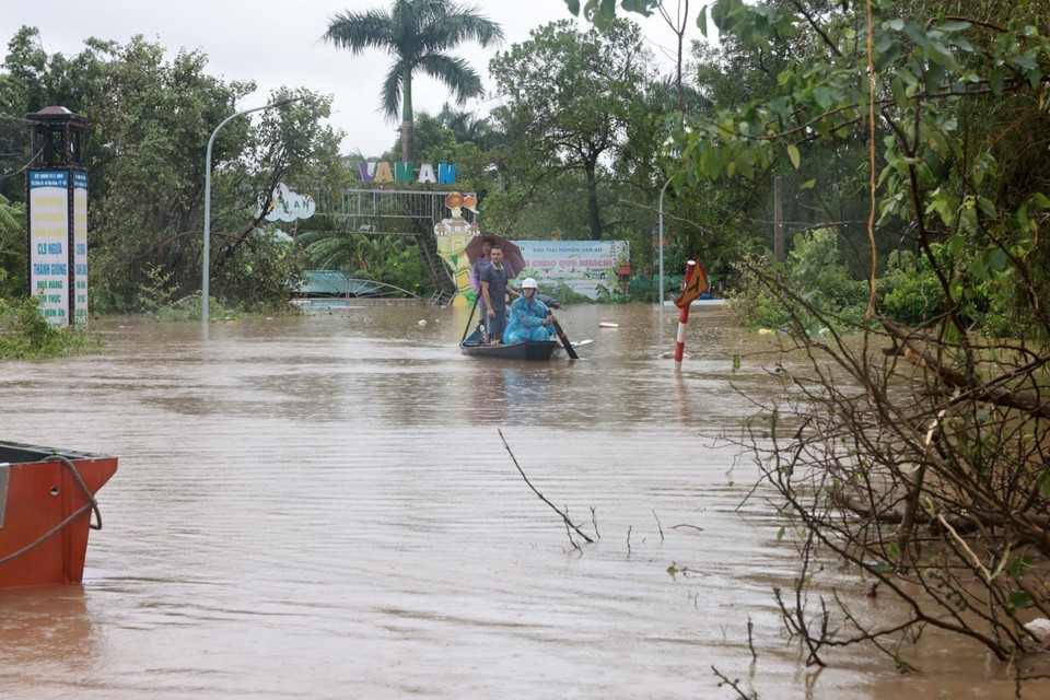 Người dân thôn Đại Lan phải di chuyển bằng thuyền do thôn bị ngập nặng. (Ảnh: Trần Việt/TTXVN)
