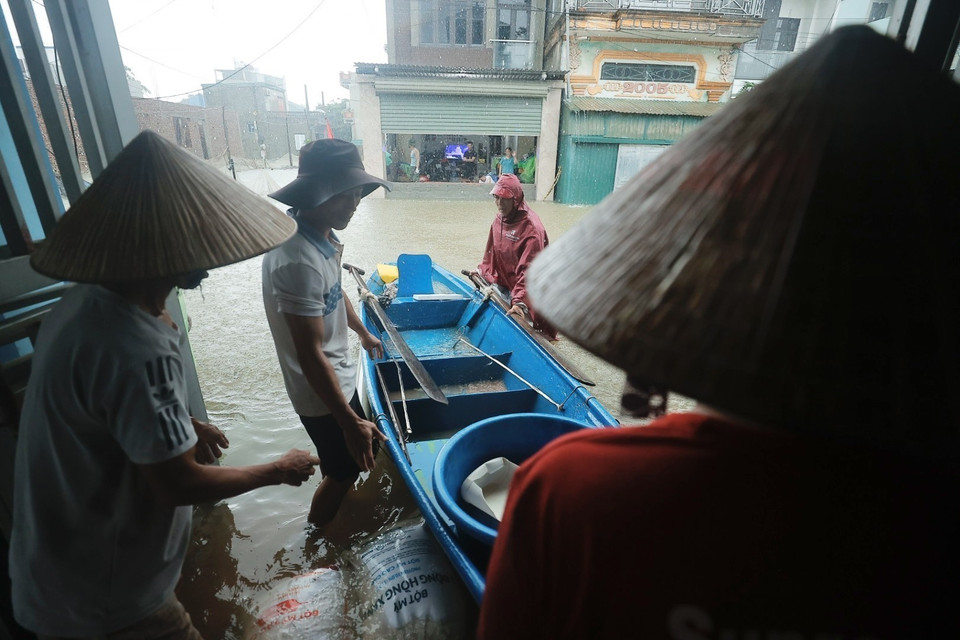 Người dân hỗ trợ đắp bao cát trước cửa nhà các hộ trong thôn. (Ảnh: Minh Quyết/TTXVN)
