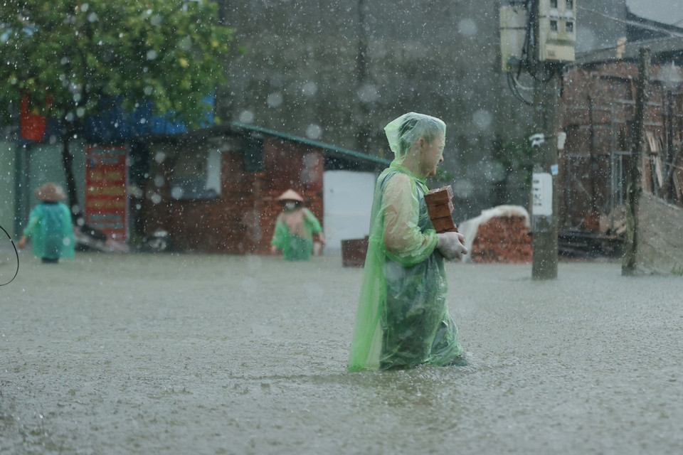 Người dân khẩn trương gia cố khi nước tràn vào nhà. (Ảnh: Minh Quyết/TTXVN)