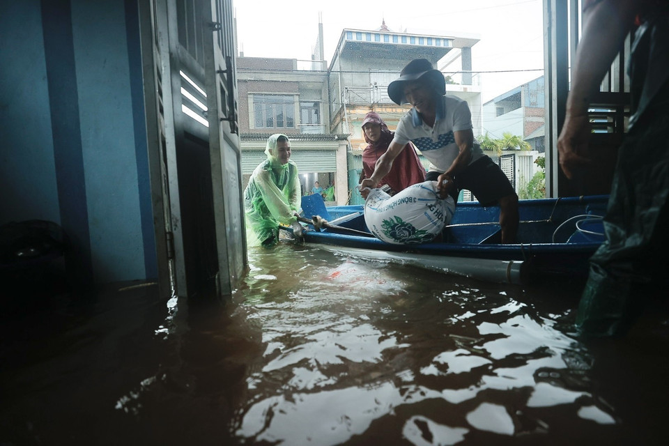 Người dân hỗ trợ đắp bao cát trước cửa nhà các hộ trong thôn. (Ảnh: Minh Quyết/TTXVN)