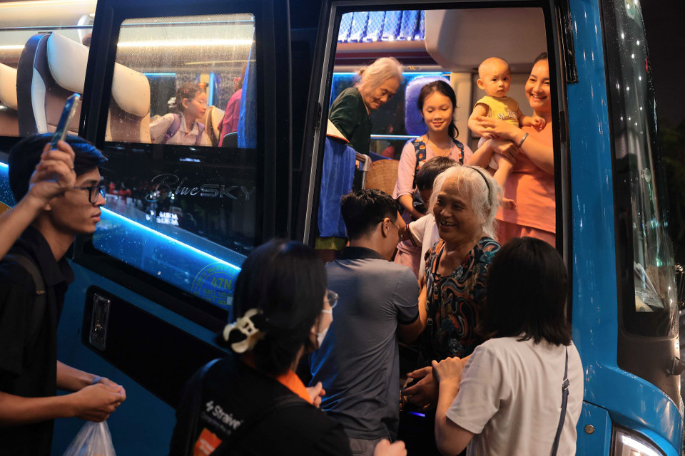 Người dân phường Yên Phụ vui mừng khi đến nơi tránh trú mới. (Ảnh: Hoàng Hiếu/TTXVN)