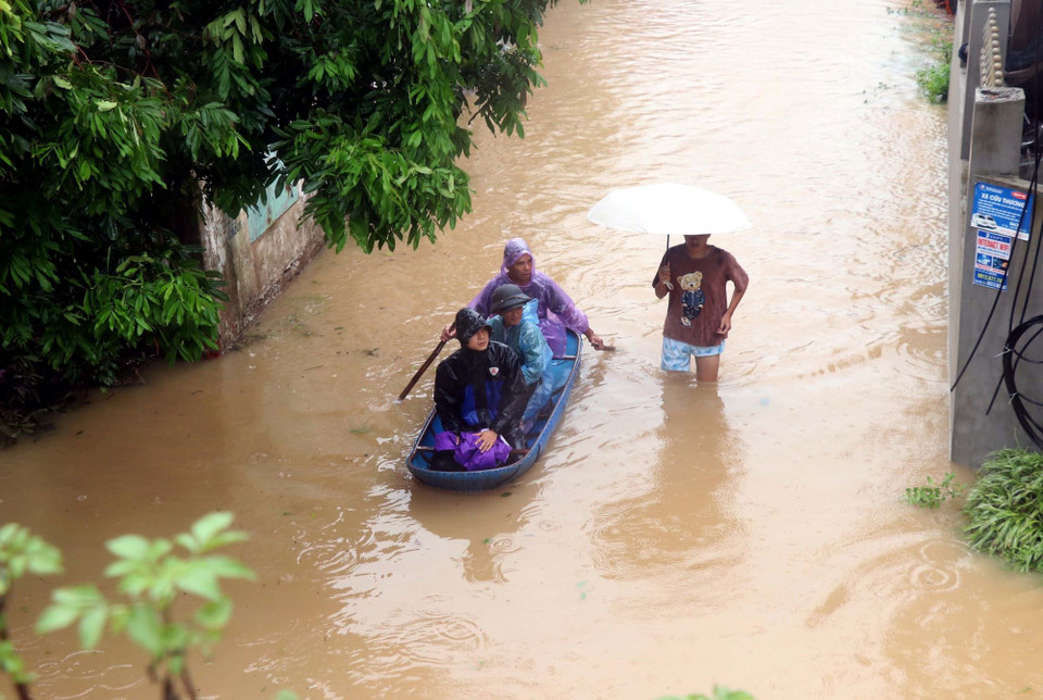 Người dân phường Lam Sơn, thành phố Hưng Yên dùng thuyền để qua lại khi nước sông Hồng dâng cao. (Ảnh: Đinh Văn Nhiều/TTXVN)