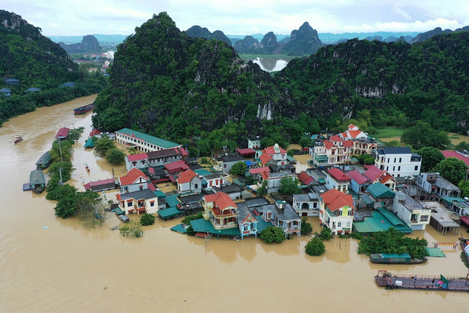 Nước dâng cao trên sông Hoàng Long khiến nhiều hộ dân bị ngập nhà cửa. (Ảnh: Minh Đức/TTXVN)