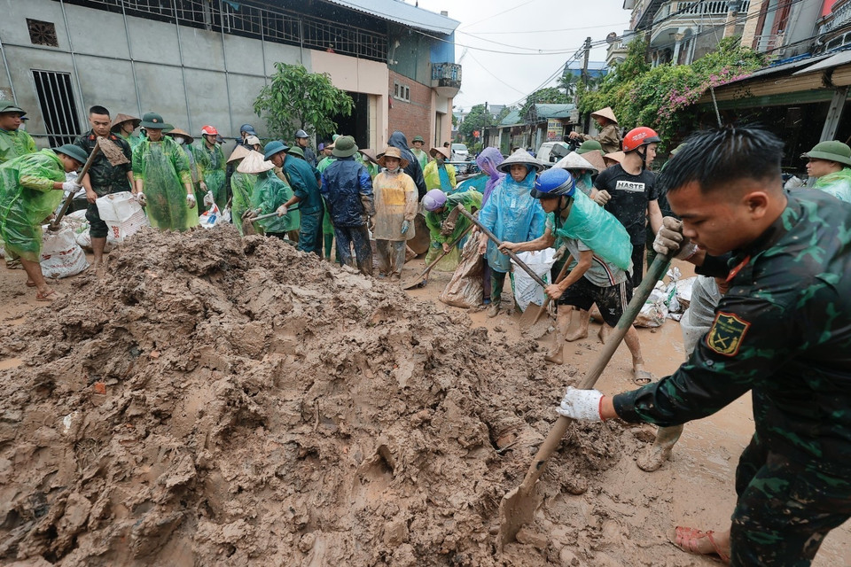 Chiến sỹ Trung đoàn 102 và người dân chuẩn bị bao tải đất để gia cố đê sông Tích, ngăn nước tràn qua đê. (Ảnh: Minh Quyết/TTXVN)