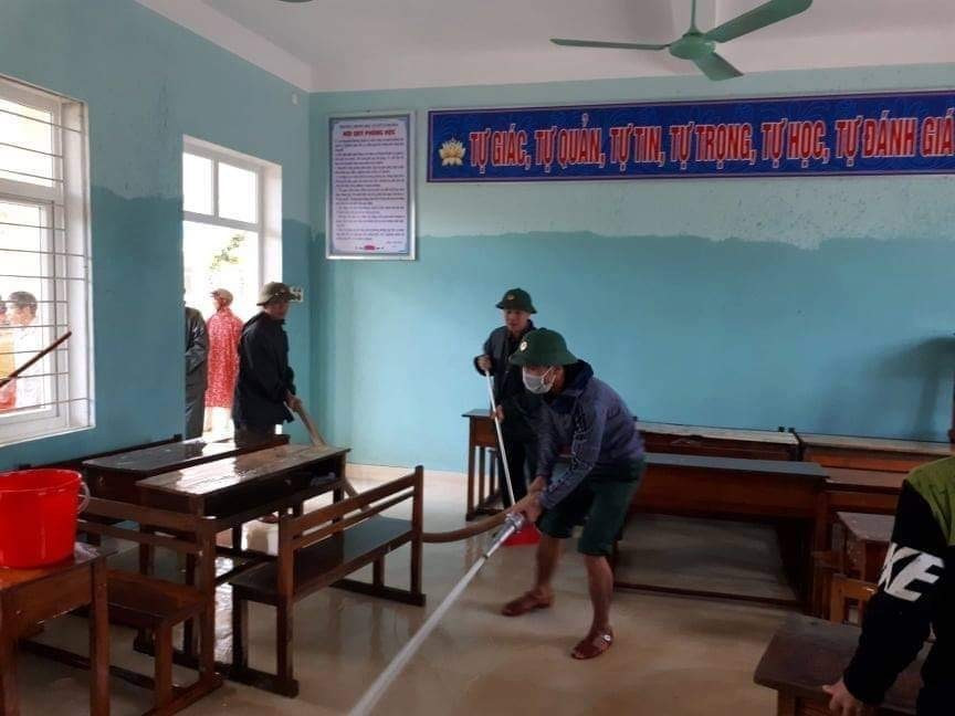 Lực lượng bộ đội cùng người dân tham gia dọn vệ sinh trường THCS Cảnh Hóa, huyện Quảng Trạch (Quảng Bình) để đón học sinh trở lại. (Ảnh: Đức Thọ/TTXVN)