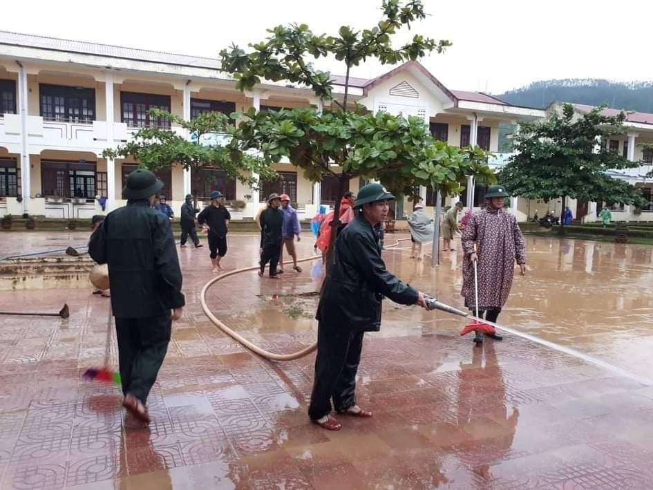 Lực lượng bộ đội cùng người dân tham gia dọn vệ sinh trường THCS Cảnh Hóa, huyện Quảng Trạch (Quảng Bình) để đón học sinh trở lại. (Ảnh: Đức Thọ/TTXVN)