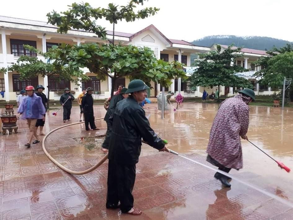 Lực lượng bộ đội cùng người dân tham gia dọn vệ sinh trường THCS Cảnh Hóa, huyện Quảng Trạch (Quảng Bình) để đón học sinh trở lại. (Ảnh: Đức Thọ/TTXVN)