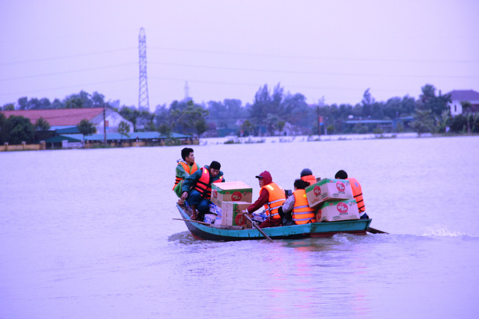 Vận chuyển hàng cứu trợ bằng xuồng máy vào các vùng ngập sâu tại Hà Tĩnh. (Ảnh: Hoàng Ngà/TTXVN)