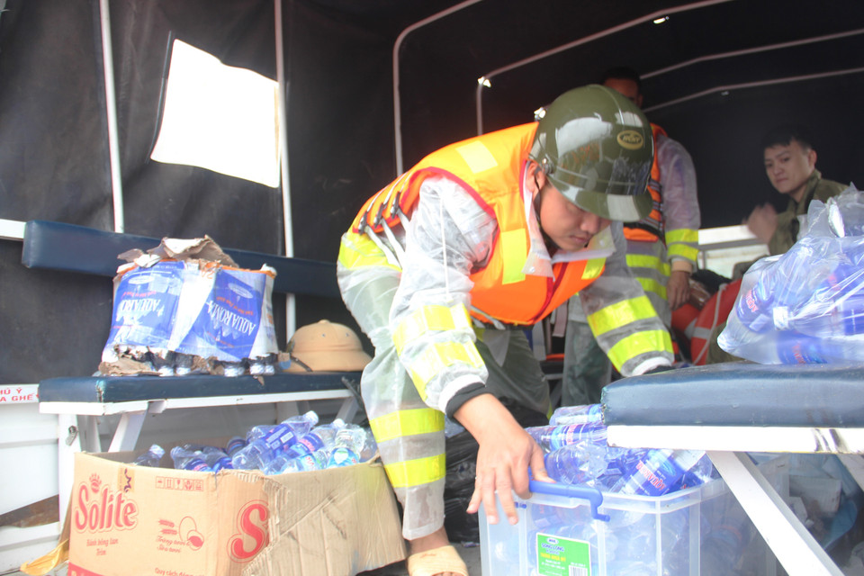 Lực lượng công an huyện Thạch Hà, Hà Tĩnh hỗ trợ các đoàn cứu trợ vận chuyển hàng. (Ảnh: Hoàng Ngà/TTXVN)