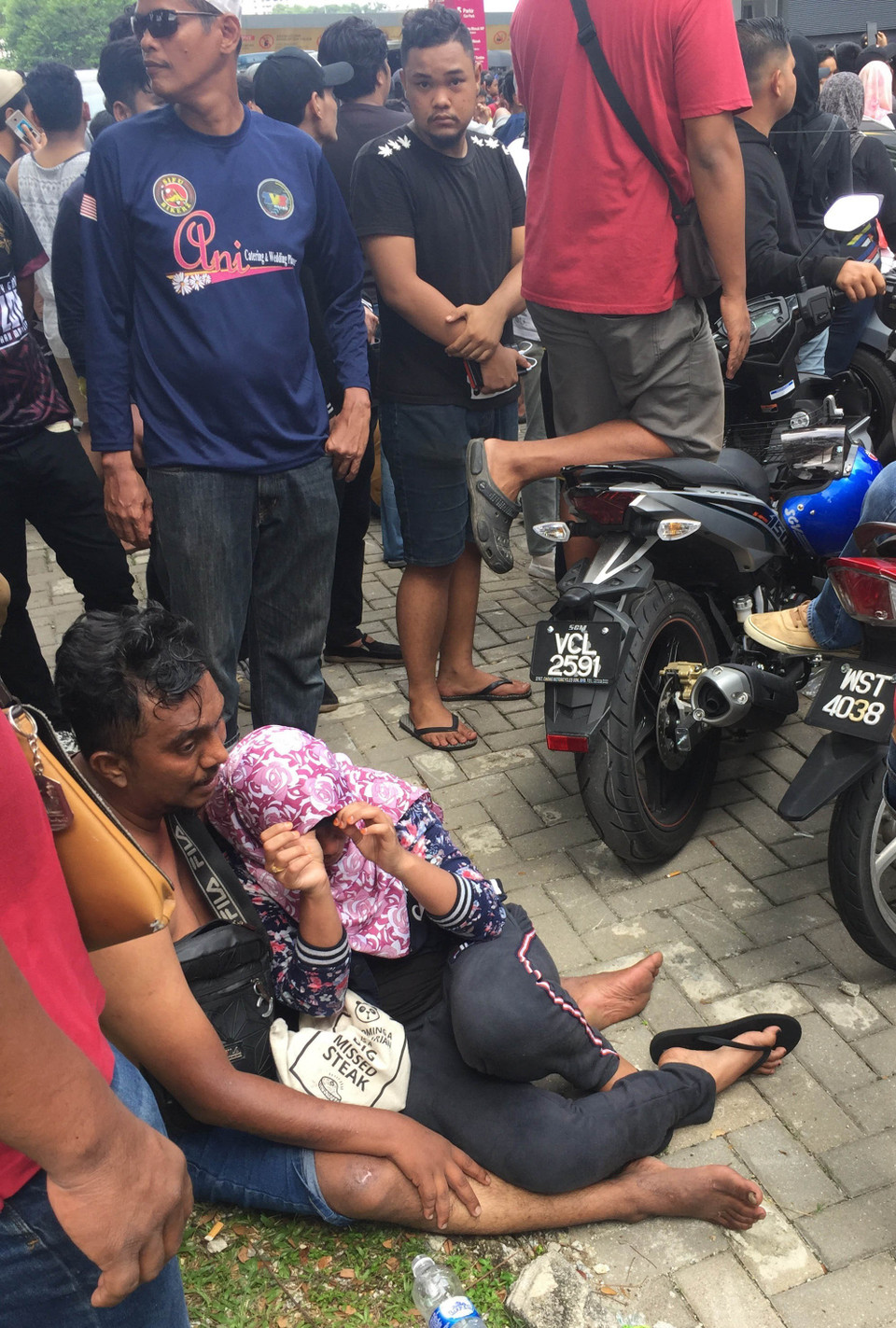 Do chờ đợi quá lâu dưới trời nắng nóng và hàng nghìn cổ động viên đến đây xếp hàng từ đêm 8/12, đã có rất nhiều người bị kiệt sức hoặc ngất xỉu. (Ảnh: Hoàng Linh/TTXVN)