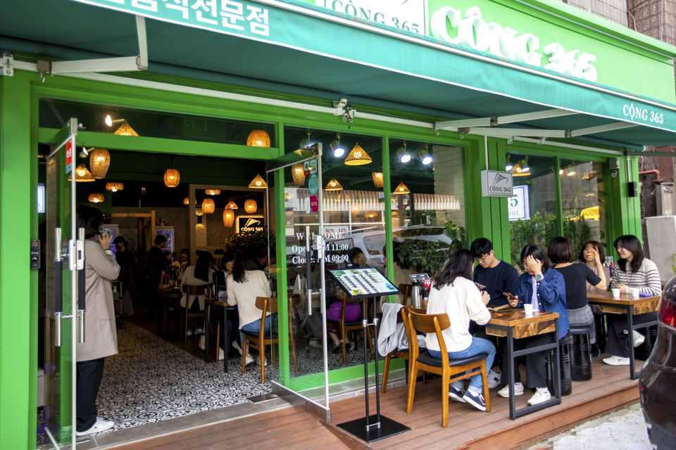 Mặc dù thời tiết bắt đầu nắng nóng song thực khách Hàn Quốc vẫn chấp nhận ngồi bên ngoài để thưởng thức món ăn truyền thống Việt Nam tại nhà hàng Cộng 365. (Ảnh: Anh Nguyên/TTXVN) 