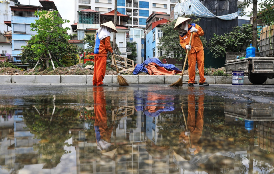Các công nhân làm việc tại công trình xén dải phân cách, trục giao thông Liễu Giai-Văn Cao luôn đeo khẩu trang đảm bảo phòng chống dịch. (Ảnh: Thành Đạt/TTXVN)