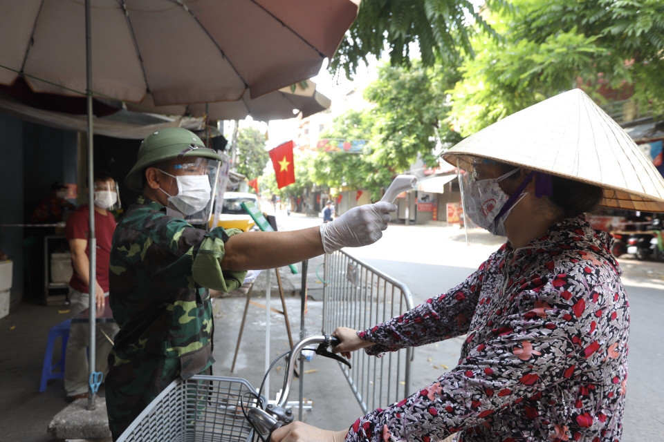 Lực lượng chức năng tại Thị trấn Phùng, huyện Đan Phượng, Hà Nội kiểm soát chặt chẽ người đi chợ dịp nghỉ lễ Quốc khánh. (Ảnh: Minh Quyết/TTXVN)