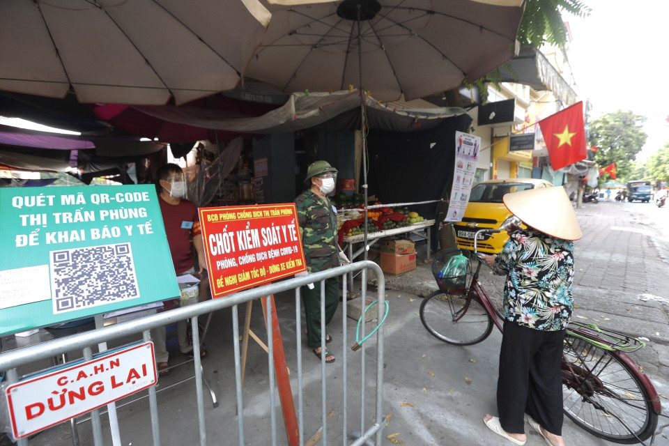 Lực lượng chức năng kiểm soát chặt chẽ người đi chợ dịp nghỉ lễ Quốc khánh tại Thị trấn Phùng, huyện Đan Phượng, Hà Nội. (Ảnh: Minh Quyết/TTXVN)