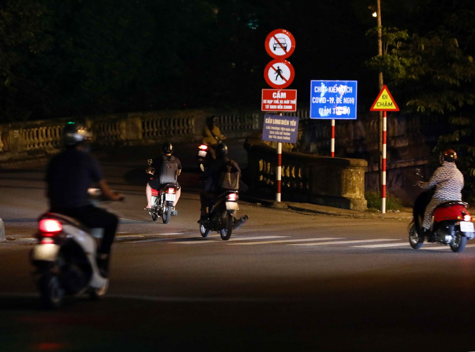 Người dân di chuyển qua cầu Long Biên mà không phải dừng để kiểm soát giấy đi đường. (Ảnh: Phạm Kiên/TTXVN)