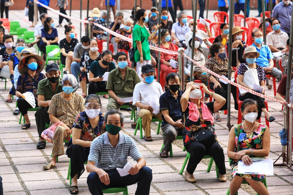 Người cao tuổi quận Hoàn Kiếm ngồi xếp hàng đảm bảo giãn khoảng cách phòng chống dịch. (Ảnh: Thành Đạt/TTXVN)
