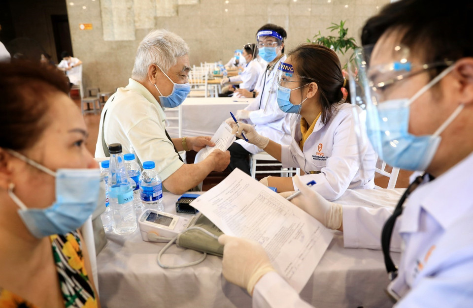 Trước tiêm, nhân viên y tế hỏi kỹ lưỡng về tiền sử dị ứng thuốc và thức ăn đối với nhóm người cao tuổi. (Ảnh: Thành Đạt/TTXVN)