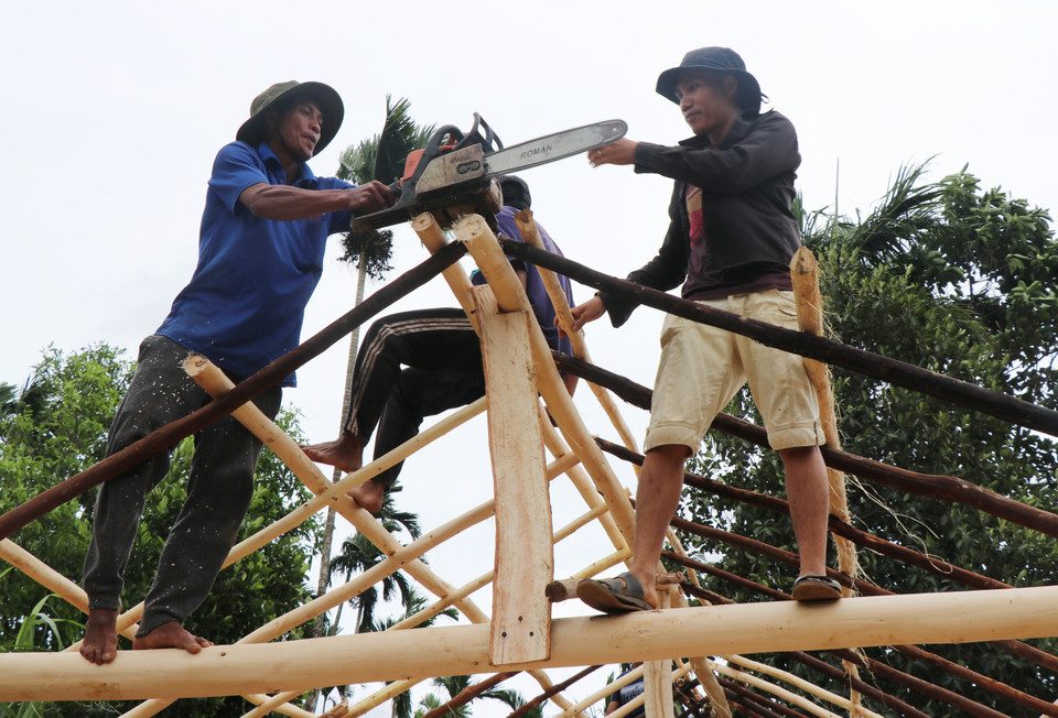 Người dân làng Bờ Reo chung tay dựng lại nhà bị sập cho người dân sau bão. (Ảnh: Phạm Cường/TTXVN)