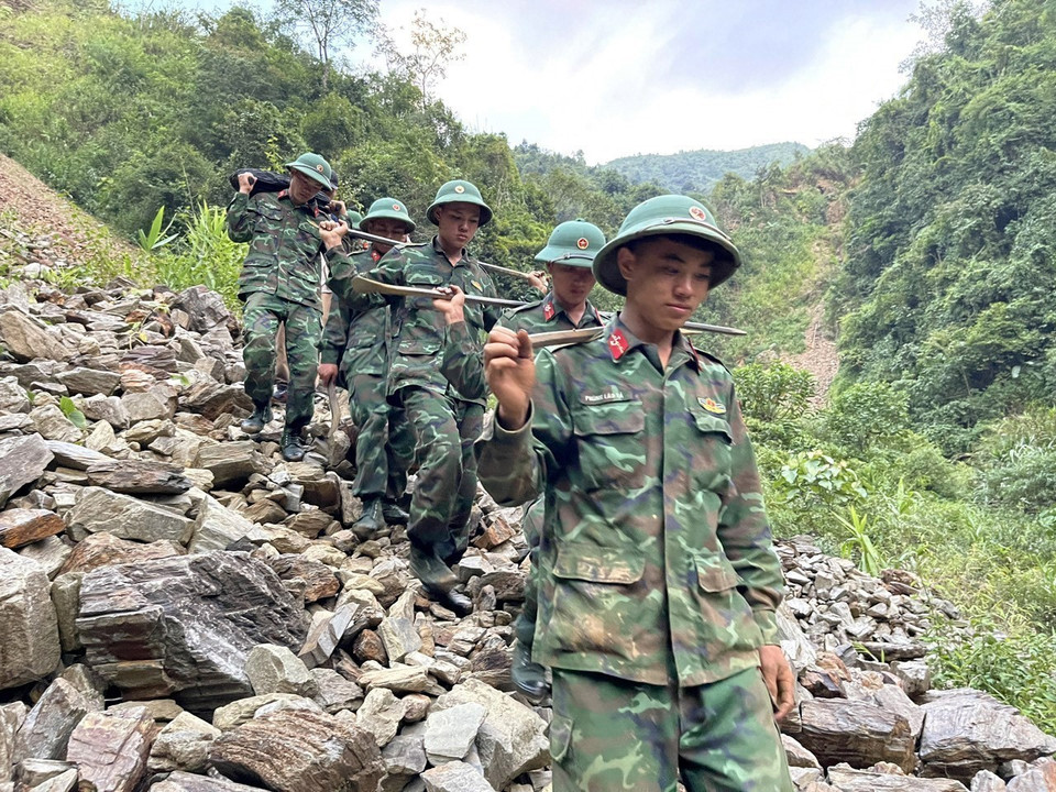 Lực lượng công binh vượt qua khó khăn vận chuyển tư trang và vật liệu nổ đi bộ vào bãi vàng Nậm Suổng thuộc xã Vàng San, huyện Mường Tè. (Ảnh: Việt Hoàng/TTXVN)