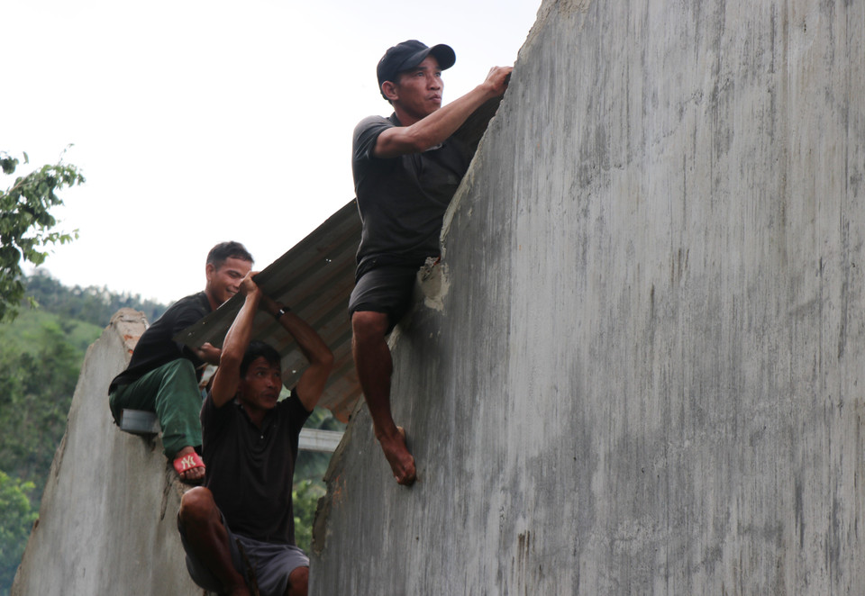 Ngay sau bão tan, người dân làng thôn Bờ Reo đã đến hỗ trợ gia đình anh Vuối lợp lại mái nhà. (Ảnh: Phạm Cường/TTXVN)