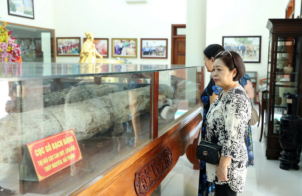 Du khách tham quan hiện vật cọc Bạch Đằng được bảo tồn nguyên trạng tại khu di tích. (Ảnh: Hoàng Hiếu/TTXVN)