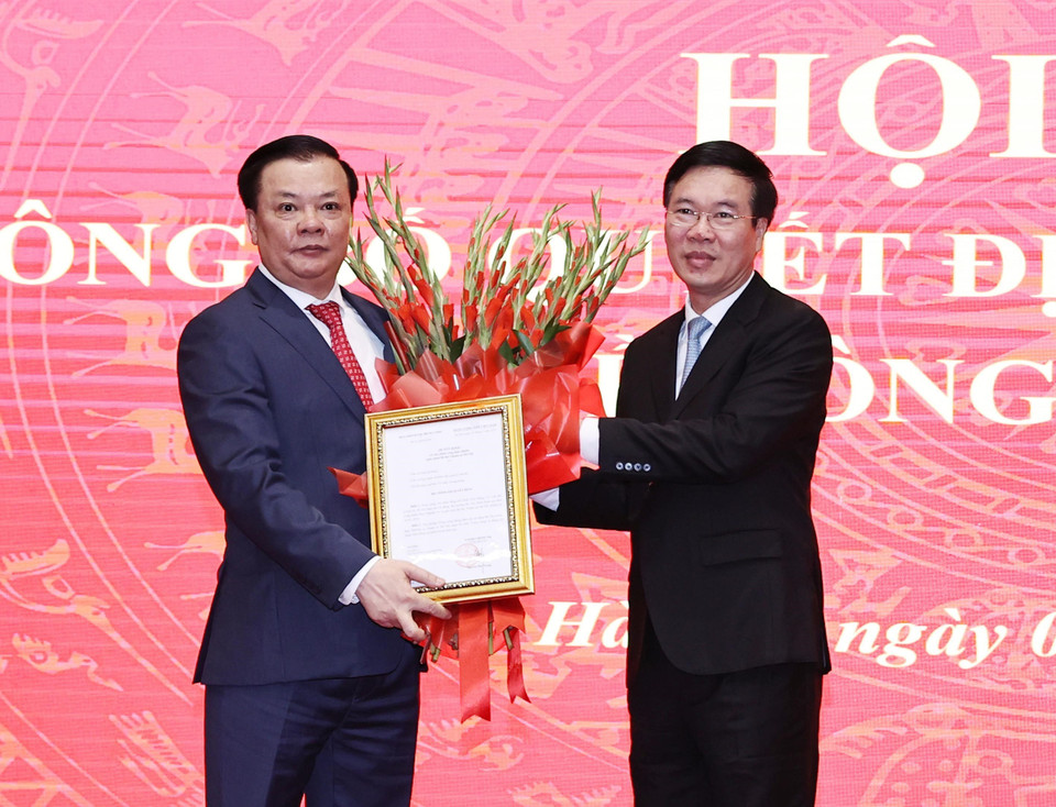 Ông Võ Văn Thưởng trao Quyết định của Bộ Chính trị phân công ông Đinh Tiến Dũng giữ chức Bí thư Thành ủy Hà Nội. (Ảnh: Trọng Đức/TTXVN)