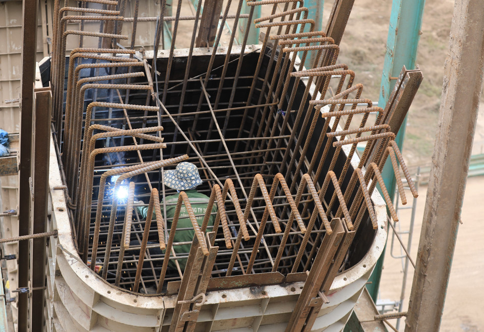 Một công nhân đang cần mẫn làm việc tại trụ Cầu Vĩnh Tuy 2. (Ảnh: Hoàng Hiếu/TTXVN)