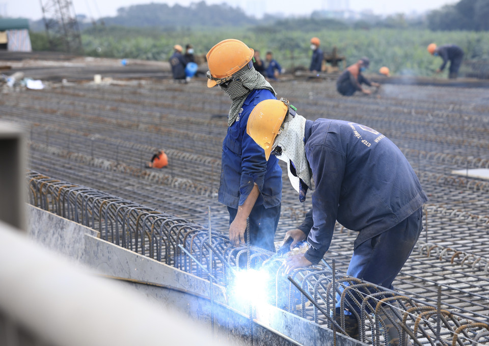 Nhiều công nhân đón Tết Dương lịch 2022 ngay trên công trường Cầu Vĩnh Tuy 2. (Ảnh: Hoàng Hiếu/TTXVN)