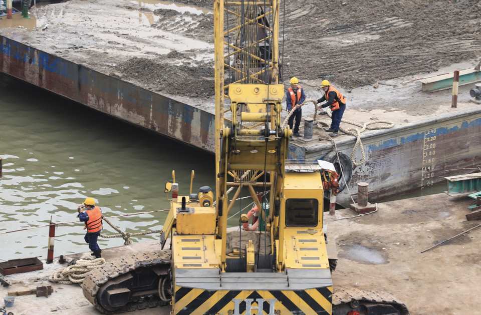 Các công nhân trên công trường cầu Vĩnh Tuy 2 làm xuyên Tết Dương lịch để đảm bảo tiến độ. (Ảnh chụp sáng 2/1/2022). (Ảnh: Hoàng Hiếu/TTXVN)