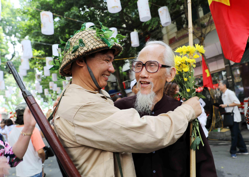 Tái hiện hình ảnh cha con gặp mặt trong ngày Giải phóng thủ đô. (Ảnh: Nhật Anh/TTXVN)