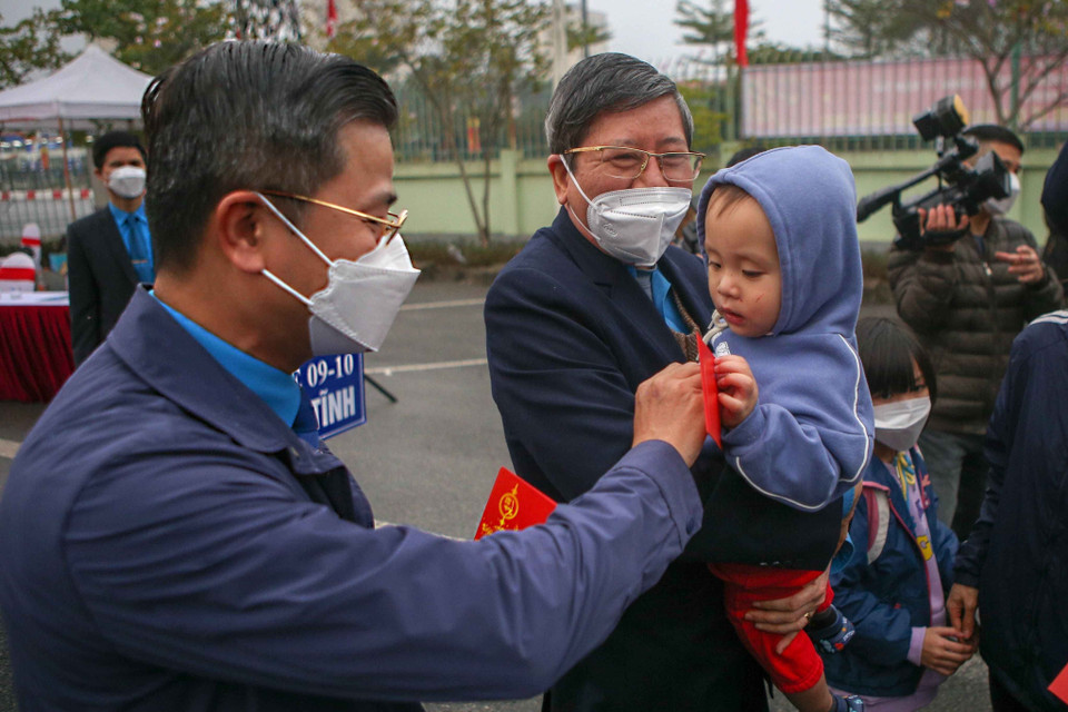 Chủ tịch Liên đoàn Lao động thành phố Hà Nội Nguyễn Phi Thường trao quà cho con công nhân lao động. (Ảnh: TTXVN phát)