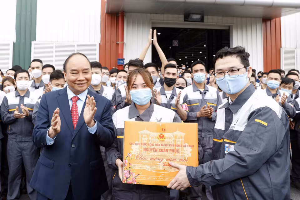 Chủ tịch nước Nguyễn Xuân Phúc tặng quà Tết công nhân lao động Công ty cổ phần sản xuất và kinh doanh Vinfast. (Ảnh: Thống Nhất/TTXVN)