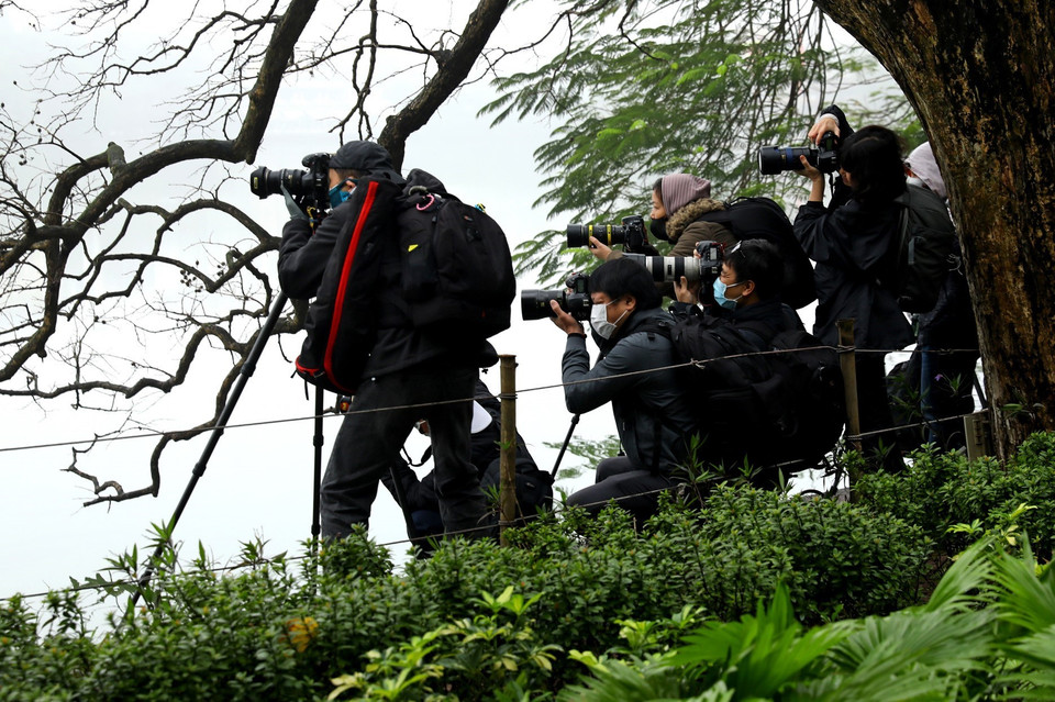 Tháp Rùa luôn có sức hút mạnh mẽ với giới đam mê nhiếp ảnh và khẩu trang không làm ảnh hưởng tới công việc sáng tác của họ. (Ảnh: Ngọc Hà/TTXVN)